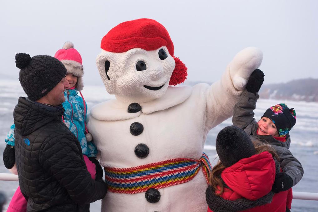 Bonhomme Carnaval meets a family in winter aboard the Québec-Lévis Ferry.